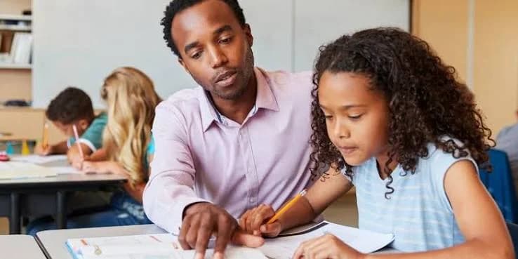 A teacher supporting a young learner during class